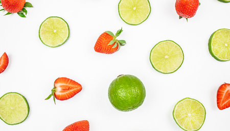 citrus fruit lime and sliced strawberries on white background. Colorful pattern.の写真素材