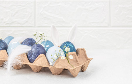 Easter eggs with blossoms spring flowers in paper tray on a white background. top view. copy space.の写真素材