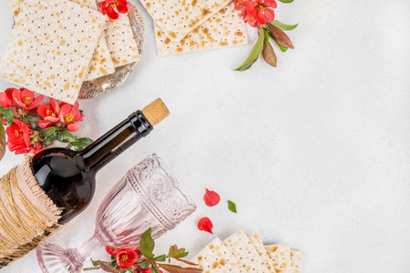 Matzah, Bottle of wine and traditional Jewish matzo bread, spring blossom flowers on a light background, top view. copy space.の写真素材