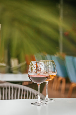 Two glasses of wine on a white table in a cozy setting.の写真素材