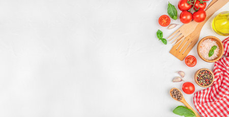 Tomatoes, basil, garlic, salt, pepper, olive oil, and wooden cooking utensils arranged on a white background. Italian cooking ingredients and utensils with copy space.の写真素材