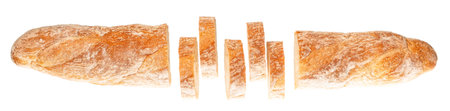 Freshly baked rustic bread loaf sliced on white background.