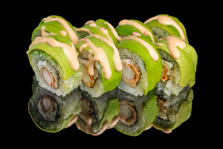 Green sushi rolls with avocado topping, fried shrimp and spicy sauce on black background,の写真素材