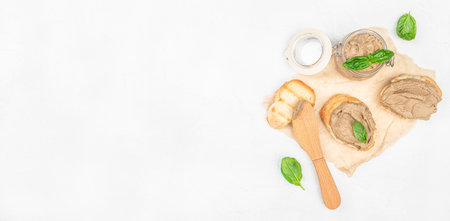 Creamy chicken liver pate with fresh basil on toasted bread, Long banner format. top view. copy...