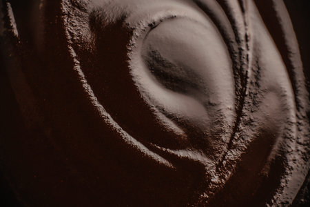 Abstract dark chocolate texture with smooth cocoa surface and elegant swirl pattern, ideal background for luxury food packaging, branding and advertising.の写真素材