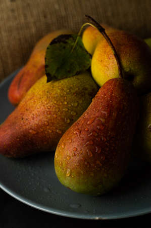 Ripe pears on a gray plate and a dark background. Still life with fruits.の写真素材