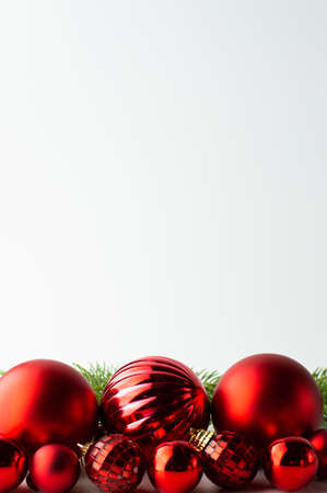 Festive background from red textured Christmas balls and sprigs of fir. Postcard with space for writing text.の写真素材