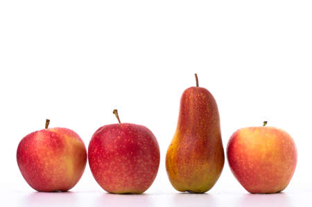 Fresh, ripe apples and one pear are placed in one row on a white background.