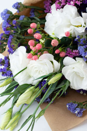 A fragment of a delicate bouquet with white eustoma, pink hypericum, colored limonium.の写真素材