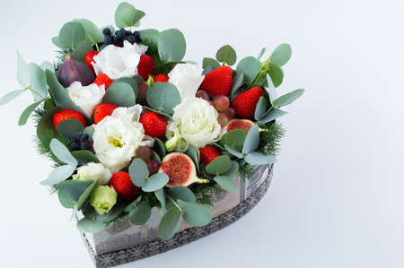 Heart shaped bouquet of flowers and berries strawberry on a white background.の写真素材