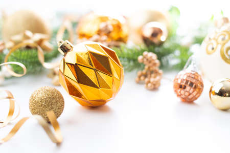 Christmas background in green-gold tones with bokeh effect. Gold Christmas ball with decor on a white background.の写真素材