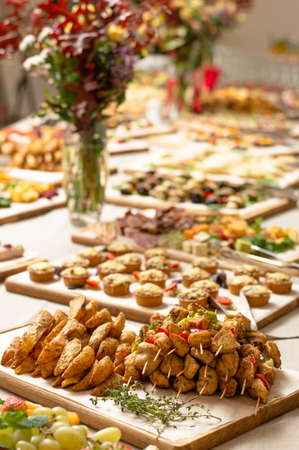 A festive buffet with lots of delicious dishes and colorful bouquets. Catering.