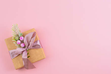 On a light pink background with a place to write the text, there is a beautiful box with a gift.