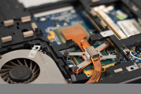 Blurred image of a fragment of a disassembled laptop. Cooler in the dust. Laptop repair.