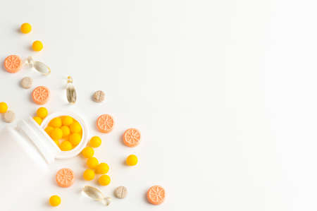 Different types of pills lie on a white background with space for writing the text.の写真素材