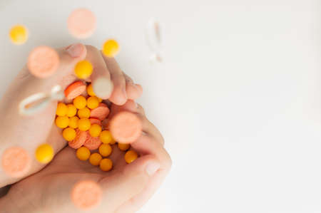 Blurred image of pills falling into the hands of a child on a white background.の写真素材