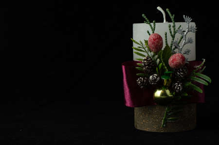 On a black background, a blurred image of a Christmas candle with festive decor. New Year card with space for writing text.の写真素材