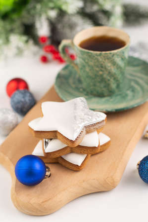 Blurred image of gingerbread cookie on a plank, a cup of coffee and Christmas decor.Christmas background.の写真素材