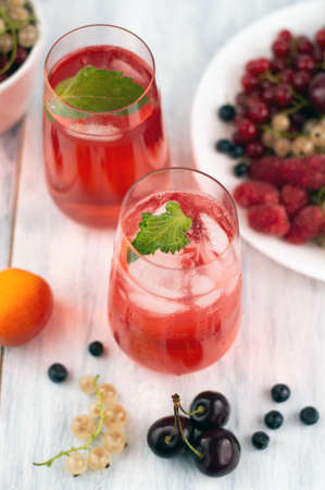 Blurred image of summer cocktails with ice and fruits on the table. summer background.