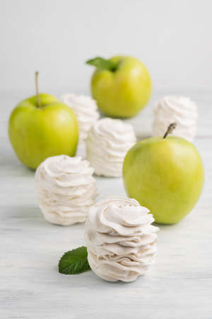 Blurred image of marshmallows and apples on a light background. The concept of proper desserts.の写真素材