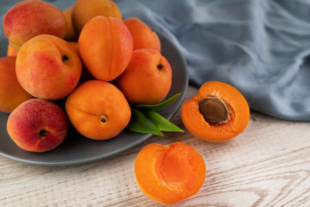 Blurred image of ripe apricots in a plate on a light table. fruit background.