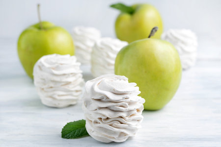 Blurred image of marshmallows and apples on a light background. The concept of proper desserts.の写真素材