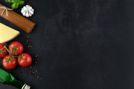 Spaghetti, tomatoes, garlic, basil, pepper, cheese, olive oil on a dark background with space for writing text.の写真素材