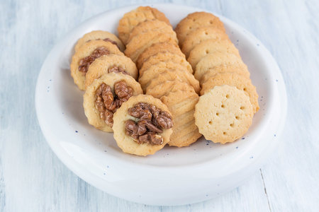 Different cookies in a plate on a light wooden table. home food concept.の写真素材