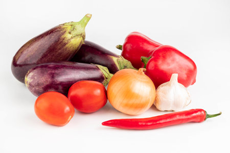 On a white background pepper, tomatoes, garlic, onion, eggplant. vegetable background.の写真素材