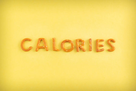 The word calories is lined with cookies on a yellow background.の写真素材
