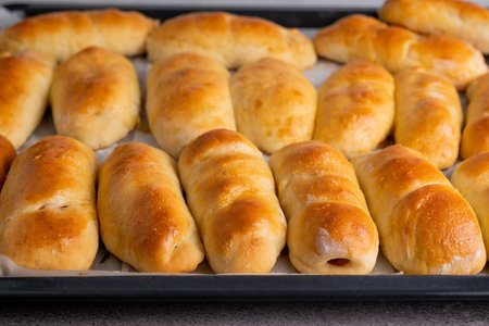 Baked yeast buns on a baking sheet. The concept of home baking.の写真素材