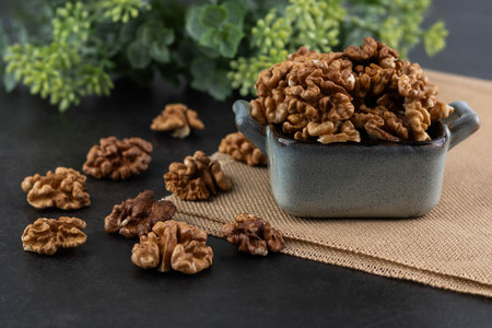 On a dark background in a gray plate - a walnut kernel.