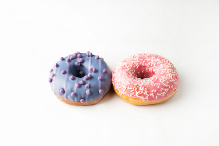 Donuts with pink and purple glaze on a white background.の写真素材