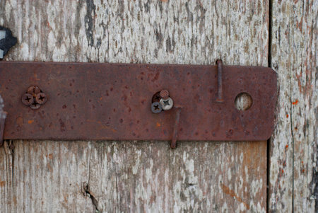 Old rusty hinged on the old wooden door, closeup of photoの写真素材