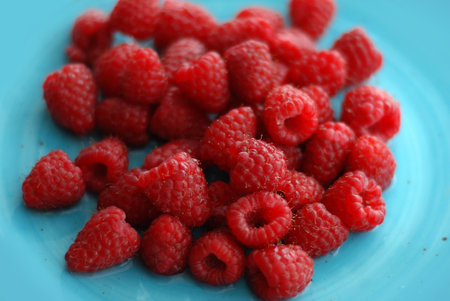 Raspberries on a blue plate, close-up, macro