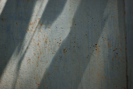 Rusty corrugated metal texture with shadow on the wall.