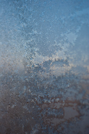 Frosty natural pattern on winter window glass as an abstract background