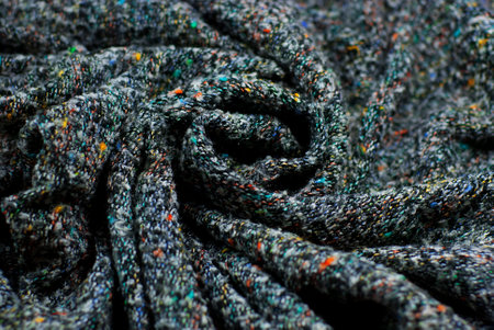 The texture is soft, light, wool, gray, boucle fabric. It has folds twisted in a circle