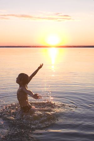 boy playing on the evening beachの写真素材