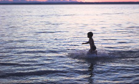 boy running on the evenng beachの写真素材