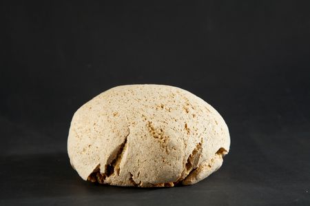 loaf isolated on black background with small shadow and cracks on surface