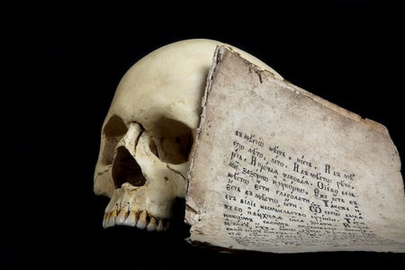 craniums and old book's paper isolated on blackの写真素材