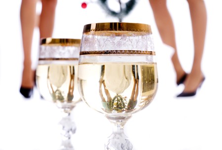 Glasses of champagne with girls' legs reflection の写真素材