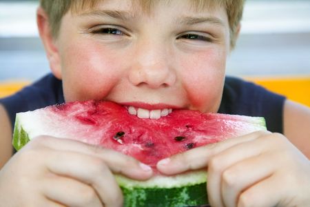 portrait of happy boy eating water-melon の写真素材