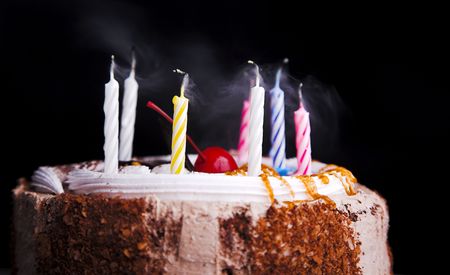 birthday cake with candle isolated on black 