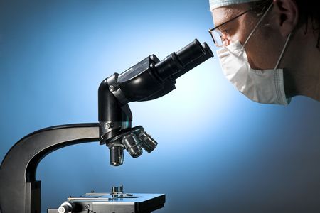 Closeup of a male researcher looking through microscopeの写真素材