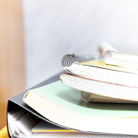 stack of books, folders and notebooks. Shallow DOF