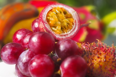 different tropical fruits - passion fruit, rambutan and grapeの写真素材