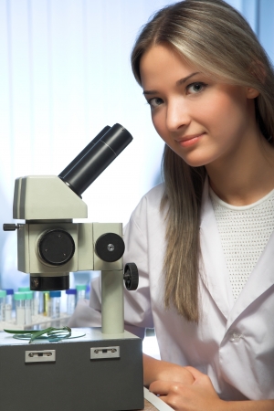 beauty researcher looking through microscope in laboratoryの写真素材