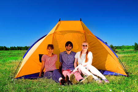 Young people relaxing on camping near the tentの写真素材